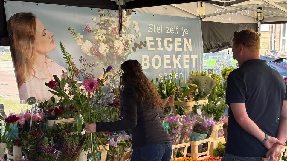 Bloemenkraam-met klant-die-we-helpen-met-boeket-samen-stellen